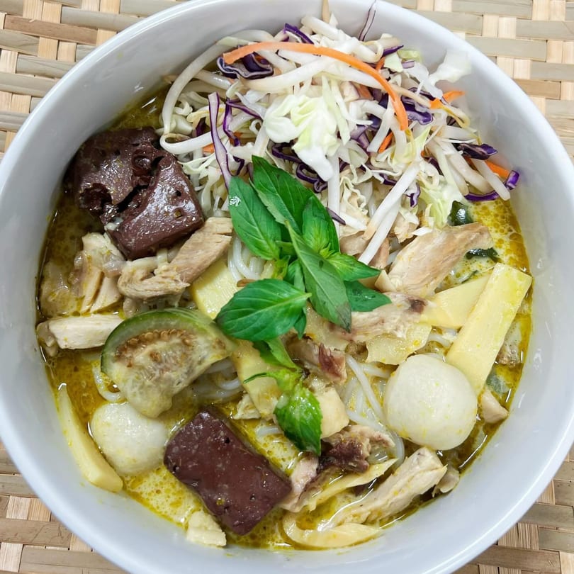 Jumpa Lao Thai Bistro's green curry with noodles, chicken, bamboo shoots, and fresh vegetables.